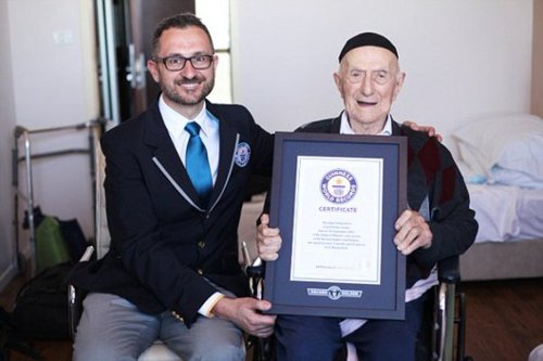 Guinness World Records’ Head of Records Marco Frigatti and 112-year-old Israel Kristal. Guinness World Records 