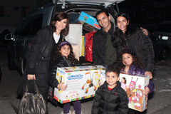 Slovie [L] with a family volunteering to help during a Hanukkah Sandy Relief drive. 
